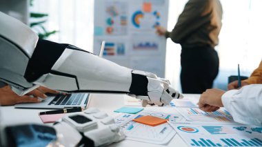 Robot Kol modern ofis ortamında insan takımını destekler, işbirliği ve yenilikçi teknoloji yoluyla veri analizi ve stratejik planlamayı kolaylaştırır. Noogenesis