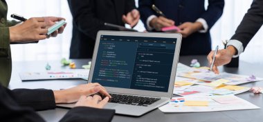 Analizci ekibi yaratıcı ve analitik beyin fırtınası fikri için bilgisayar ekranında BI veri paneli olan yapışkan bir not kullanıyor. Pazarlama stratejisi için finansal veri görselleştirme teknolojisini analiz et. Dahi.