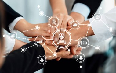 Ellerin bir araya geldiği takım çalışmasının güçlü bir görsel temsili, işbirliğini ve CRM 'nin güçlü iş ilişkileri ve başarısını sembolize ediyor. Dostluk