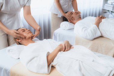 Kafkasyalı çift stres önleyici kafa masajının keyfini çıkarıyor ve lüks otellerde ya da otel spa salonlarında gündüz kaplıcalarında yüz güzelliği eğlencelerini şımartıyor. Sessiz.