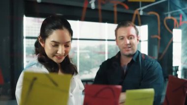 Genç kendine güvenen iş kadını projeyi uzman yatırımcıya sundu. Profesyonel proje yöneticisi başlangıç projesini açıklamak için yapışkan notlar kullanır, beyin fırtınası fikirlerini yatırımcıya paylaşır. Yönlendirici.