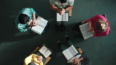 Yetenekli çeşitli duaların el ele tutuşması ve daireler çizerek Tanrı 'ya dua edişinin üst görüntüsü. Kucaklarda açık incille otururken el ele tutuşan insanların yukarıdan aşağı hava görüntüsü. Sempozyum.