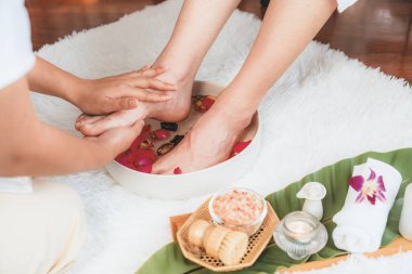 Kadınlar lüks spa salonlarında keyifli ayak masajlarına devam ederken, masör de hafif gün ışığı atmosferinde refleksoloji terapisi veya otel ayak spa 'sında. Sessiz.