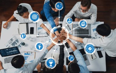 Üst düzey ofis çalışanları ofis odasında el ele tutuşarak iş sinerjisini ve iş yerindeki güçlü üretken takım çalışmasını sembolize ediyor. İş çalışanları arasındaki işbirliği ve birlik. İhtiyatlı Dostluk