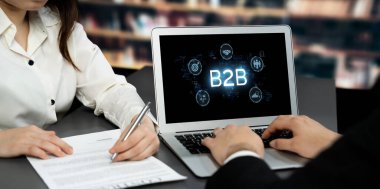 İş adamı B2B peyzajında geziniyor, iş-iş bağlantılarını geliştirmek için kullanım teknolojisi kullanıyor. B2B etkileşimini yeniden şekillendiren keşifler, iş-iş stratejilerinde yenilikleri yönlendiren araçlar. canlı