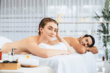 Lüks spa salonlarında sıcak mum ışığında cilt bakımı gören mutlu çift müşterisi. Sağlık kaplıcasında güzellik tedavisiyle tuz temizliği. Sessiz.