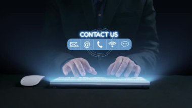 Parlak dijital temas simgeleriyle klavyeye yazı yazan ellerin yakın çekim görüntüsü. Bu görüntü, etkin iş erişimi için modern iletişim yöntemlerini temsil ediyor. Dörtgen