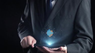 Resmi giyinmiş bir işadamı, modern iş analitiği ve iletişimini sembolize eden gelişmiş veri görselleştirme ve teknoloji unsurları içeren bir akıllı telefon taşıyor. Dörtgen