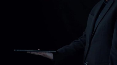 Profesyonel bir birey, teknolojinin modern iletişim uygulamalarına entegrasyonunu gösteren dijital bir cihaz üzerinde fütüristik bir sohbet yapay zekası arayüzü kurar. Dörtgen