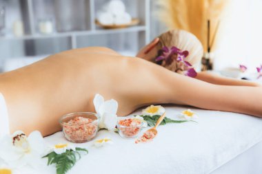 Lüks spa salonlarında sıcak mum ışığında cilt bakımı yaptıran kadın müşteri. Sağlık Spa vücut fırçasında tuz temizleme güzellik tedavisi. Sessiz.