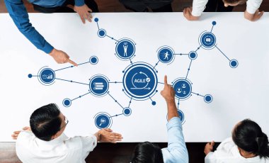 Çeşitli bir grubun, bağlantıları ve fikirleri etkili bir şekilde görselleştirmek için bir beyaz tahta kullanarak çevik metodoloji hakkında ortak bir tartışmaya girdiği dinamik bir toplantı. Dostluk