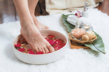 Kadınlar lüks spa salonlarında keyifli ayak masajlarına devam ederken, masör de hafif gün ışığı atmosferinde refleksoloji terapisi veya otel ayak spa 'sında. Sessiz.