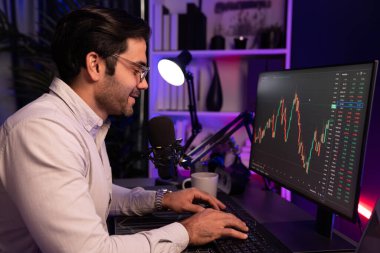 Akıllı tüccar işadamı, karanlık oda gecesinde neon ışıklı ofisteki arama pazarında yüksek kârla ekranda bilgisayar ve bilgisayar üzerinde dinamik borsa yatırımları üzerinde yoğunlaşıyor. Tahmin et..