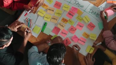 Renkli yapışkan notlarda pazarlama ve planlama stratejisi yazarken insanların yazma ve çalışma tahtası oluşturma konusunda üst düzey bir bakış açısı. Akıllı takım Kanaban tahtasını kullanarak iş performansını yönetir. Cemaat.