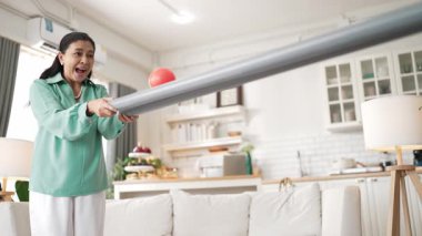 Büyükannenin elinde boru var ve göz, el koordinasyonunu geliştirmek ya da odaklanma ve konsantrasyonu arttırmak için top yuvarlama oyunu oynuyor. Yaşlı çift stresi azaltıyor. Sağlık hizmetleri. Myrmidon.