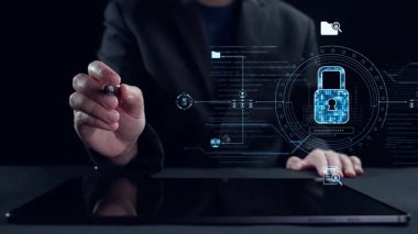 Bir iş adamı, güvenlik unsurlarıyla vurgulanan yazılım güncellemesini gösteren bir tabletle etkileşime girer. Bu görüntü dijital yeniliğin özünü yakalar. Dörtgen