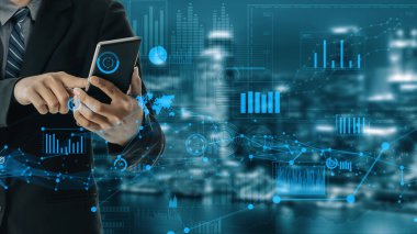 Bir iş adamı, modern bir şehir zemininde dijital analitik görüntüler sergileyen akıllı bir telefonla iletişim kurarak, iş dünyası ve yenilik üzerindeki teknolojik etkisini gözler önüne seriyor. Xenic