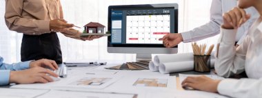 İç mimar tasarımcı grubu, daha kesin tasarım için planlar ve dizüstü bilgisayar ekran mimari yazılımı üzerinde birlikte tartışıyorlar. Modern ev tasarımı ve yenileme. İçgörü