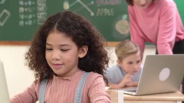 Çekici kız kodlama hızlı BTMM sınıfında kameraya bakarken mutlu öğretmen akıllı çocuk yazılım programını kontrol ediyor. Programlama kodu ve bilgisayar sistemi üzerine çeşitli öğrenci çalışmaları. Pedagoji.