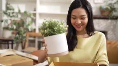 Genç girişimci, karton kutularda paketleme yapıyor ve paket etrafa saçılıyor. Çekici çevrimiçi satıcı paket taşıyor ve teslimat ve nakliye siparişine hazırlanıyor. Myrmidon.