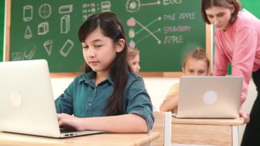 Akıllı Asyalı kız, mühendislik komut yazarken kameraya bakıyor. Çok kültürlü bir öğrenci yapay zekayı öğrenirken öğretmenler sistemi öğretiyor ya da STEM sınıfında sınıfları kontrol ediyor. Pedagoji.