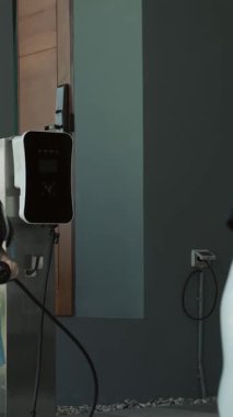 Evde şarj edilen elektrikli bir araçla okuldan yeni dönen anne ve kızın ilerici yaşam tarzı. Elektrikli araç, sürdürülebilir temiz enerjiyle çalışıyor..