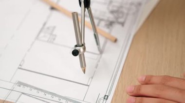 Bölücü araç ve el yazısı kullanan akıllı mimar ya da güvenlik mühendisinin videosu mimari ofisteki inşaat doğruluğu planının ayrıntılarını içeriyor. Eline odaklan. - Yakın çekim. Tanımlama.