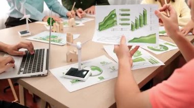 Karbon kullanımını azaltmak için yel değirmeni, ev ve ağaç modellerini kullanarak yeşil enerjiyle karışık masadaki eko ev projesini harika bir şekilde tartıştık. Eline odaklan. Tanımlama.