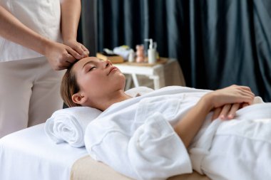 Kafkasyalı kadın stres önleyici kafa masajından ve lüks tatil beldesi ya da otel spa salonundaki modern ışık ortamında yüz güzelliği eğlencelerini şımartmaktan hoşlanıyor. Sessiz.