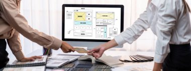 Masadaki bir grup iç mimar takımı dizüstü bilgisayarında mimari yazılım bulunan çeşitli ruh hali tahtası örneklerini seçiyor. Modern yenileme ve iç malzeme seçimi konsepti. İçgörü
