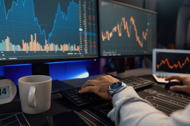 Akıllı tüccar işadamlarının elleri dinamik borsa yatırımlarına yoğunlaşarak bilgisayar ve dizüstü bilgisayara odaklanarak karanlıkta neon ışıklı ofisteki arama pazarında yüksek kar elde ettiklerini gösteriyor. Tahmin et..