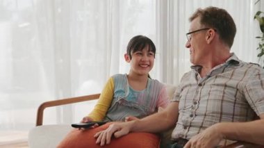 Büyükbaba ve torun birlikte TV 'de ilginç bir eğlence medyası izliyorlar. Eski üst düzey kullanım teknolojisi, genç nesil çapraz nesil ile iletişim kurarak aile bağlarını güçlendiriyor. Uyumsuzluk.