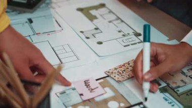 İnşaat projeleri için tasarım planlama sürecini gösteren, araçlarla dolu bir masanın üzerinde mimari planlar ve çizimler sunan profesyonel bir çalışma alanı. SACTR