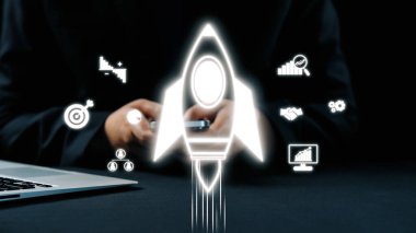 Bir roket ikonu, teknoloji grafikleri ve gösterişli ofis geçmişine karşı metriklerin yer aldığı iş büyümesi ve yeniliğin görsel temsili, yaratıcı stratejileri vurguluyor. Dörtgen