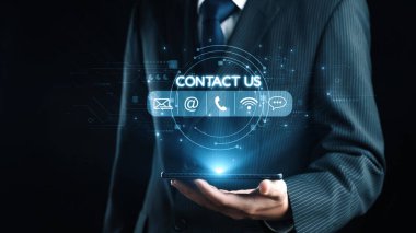 Bir iş adamı, elinde dijital temas simgeleriyle güvenli bir şekilde duran bir akıllı telefon ile müşteri ilişkileri için modern iletişim yöntemlerini betimliyor. Dörtgen