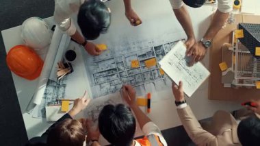 Becerikli mühendis ekibinin ev inşaatından bahsedişinin en alt görüntüsü. Mimar ya da tasarımcı grubunun planlar hakkında beyin fırtınası yapmak için tartışan ve yazan hava görüşü. Hizalama.