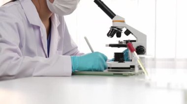 Laboratuvar kimya araştırmacısı mikroskop kullanarak yeni ilaç ya da tedavi geliştirir. Laboratuvar mikrobiyoloji ekipmanları ile bilimsel uzmanlık ile sağlık hizmetlerinin teknolojik gelişimi. Ağır çekim. Katı.