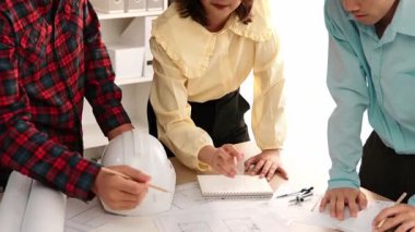 Mimari döküman, ölçüm araçları ve ahşap blokların modern ofiste etrafa saçıldığı masa üzerine planlar yapma konusunda akıllı mimar ve güvenlik mühendisi tartışması. - Yakın çekim. Tanımlama.