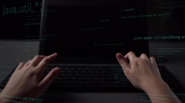 Bir programcının elleri dizüstü bilgisayarda yazarken, ekranda kod gösterirken, dijital çalışma alanında modern yazılım geliştirme ve teknoloji yeniliklerini temsil ederken görüntüsü. Xenic