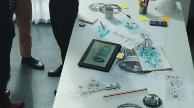 Gündelik kıyafet giymiş profesyonel mühendis ekibi masada teçhizatlı, hesap makineli, yapışkan notlu türbin motor yapısı hakkında konuşuyor. Bir grup teknisyen toplantıda el sıkışıyor. Hizalama.