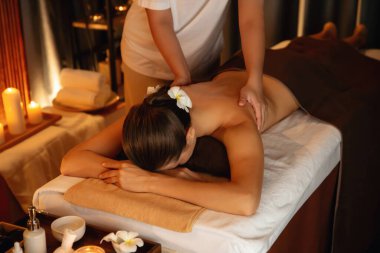 Beyaz kadın müşteri stres önleyici spa masajının keyfini çıkarıyor ve lüks otel ya da otelde sıcak mum ışığında güzellik teniyle eğleniyor. Sessiz.