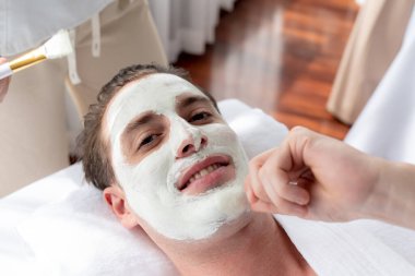 Kaplıca salonunun sakin atmosferi, insan müşterisi modern gün ışığında lüks yüz kremi masajıyla kendini yenileme zevkine kapılıyor. Yüz bakımı ve güzellik konsepti. Sessiz.