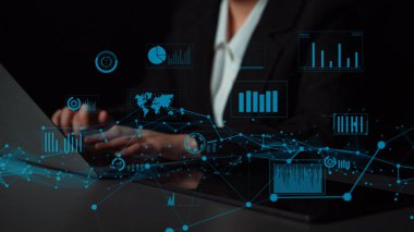 Bir iş adamı ileri teknoloji arayüzü kullanarak veri analizi yapar. Gösterişli ve modern bir çalışma ortamında çeşitli grafik ve grafikler gösterir. Xenic