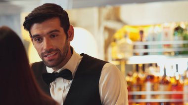 Gülümseyen zeki barmen, gece kulübünde VIP müşterilerle canlı sohbetler yapmak için güzel bir gece partisi atmosferine mükemmel bir servis sunuyor. Vinosity.