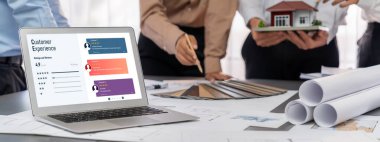 İç mimar tasarımcı grubu, daha kesin tasarım için planlar ve dizüstü bilgisayar ekran mimari yazılımı üzerinde birlikte tartışıyorlar. Modern ev tasarımı ve yenileme. İçgörü