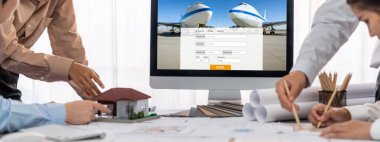 İç mimar tasarımcı grubu, daha kesin tasarım için planlar ve dizüstü bilgisayar ekran mimari yazılımı üzerinde birlikte tartışıyorlar. Modern ev tasarımı ve yenileme. İçgörü