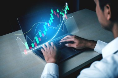 Odaklanmış bir profesyonel, kaliteli bir dizüstü bilgisayardaki gerçek zamanlı finansal verileri analiz ederek, yatırım kararlarını yönlendirmek için gelişmiş dijital grafikler ve çizelgeler kullanır. Etki