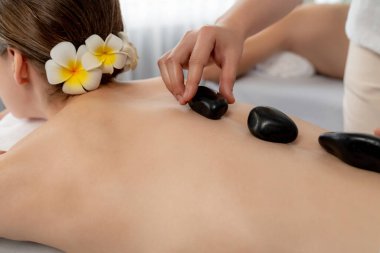 Lüks tatil köyündeki kaplıca salonunda sıcak taş masajı. Gündüz dinginliği ortam, mutlu çift müşterileri bazalt taşı masajının keyfini çıkarıyor. Rahatlatıcı bir sıcaklıkla vücudun üzerinde süzülüyorlar. Sessiz.