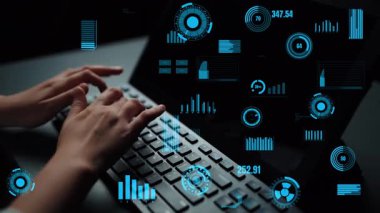 Eller dizüstü bilgisayarın üzerinde fütüristik veri görselleştirmelerinin, modern çalışma ortamında teknoloji ve yeniliklerin arkaplanının ortasında daktilo ediyor. Xenic