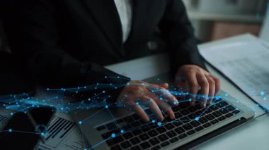 Bir iş adamı, modern ofis ortamındaki mali eğilimleri gösteren grafik ve grafiklerin görselleştirilmesiyle çevrili bir dizüstü bilgisayarla verileri analiz etmeye odaklanır. Xenic